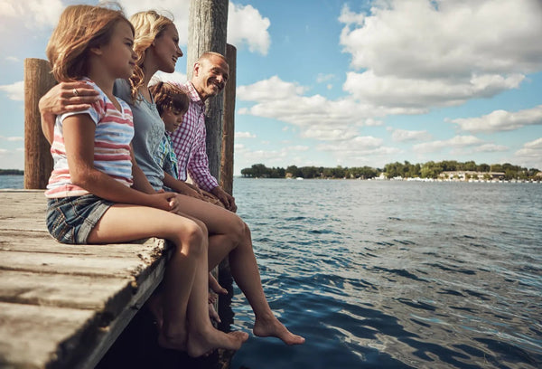 Family relaxing together on a lake dock
