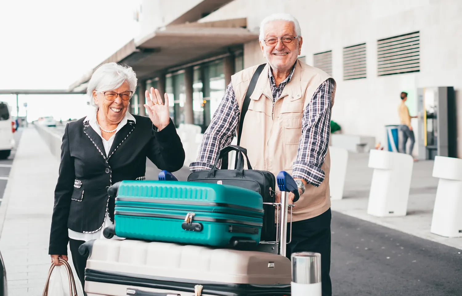 Retired couple setting off through the airport with their luggage