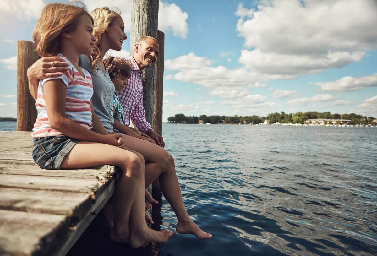 Family relaxing together on a lake dock