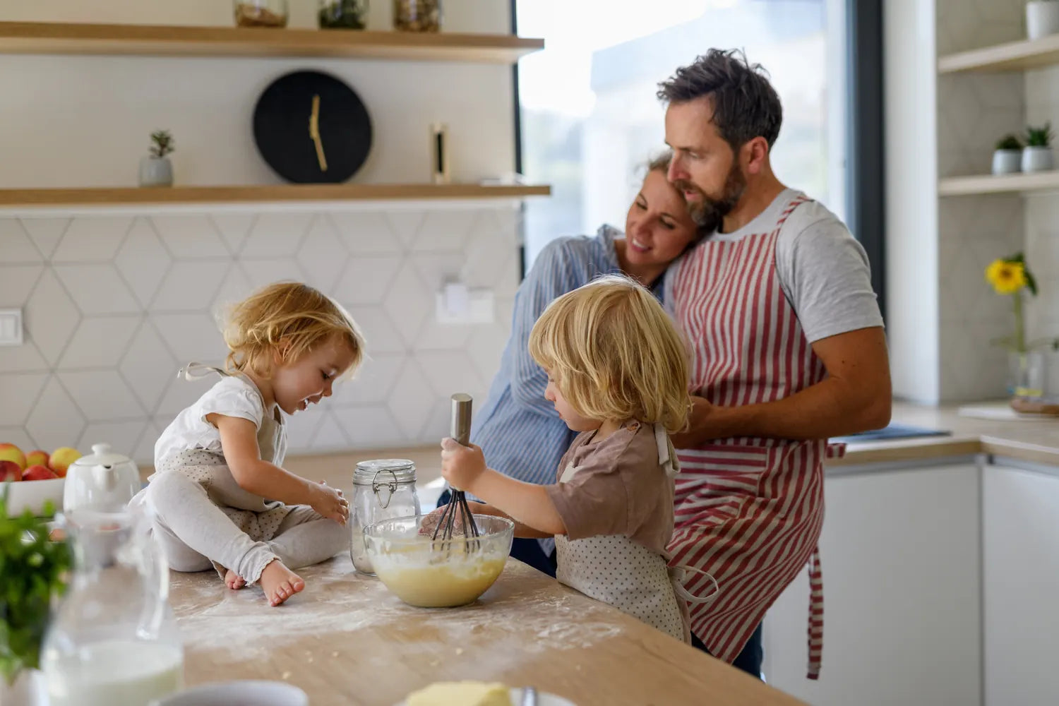 Young family making pancakes together in their kitchen